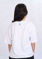 Person wearing a white t-shirt with a cross design on the back against a light grey background
