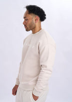 Man wearing a beige sweatshirt with text on a white background