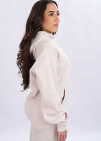 Woman wearing a light grey outfit against a white background
