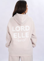 Person wearing a beige hoodie with 'LORD ELLE Apparel' text on the back against a white background God is my oath