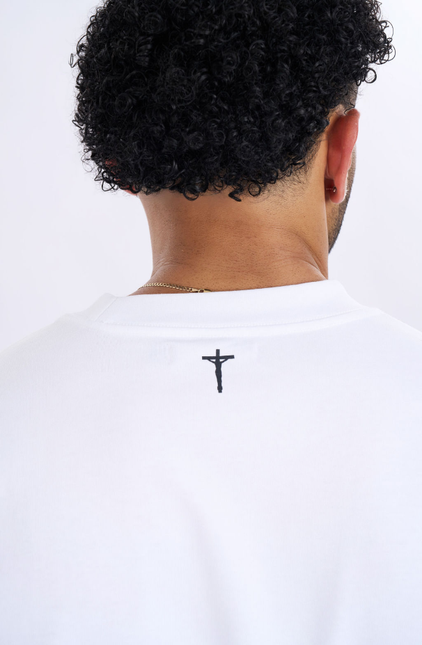 Person wearing a white t-shirt with a black cross design on a white background