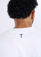 Person wearing a white t-shirt with a black cross design on a white background