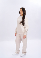 Woman wearing a beige tracksuit on a white background