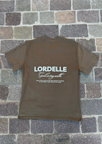 Brown t-shirt with 'LORDELLE God is my oath' text on a stone pavement background