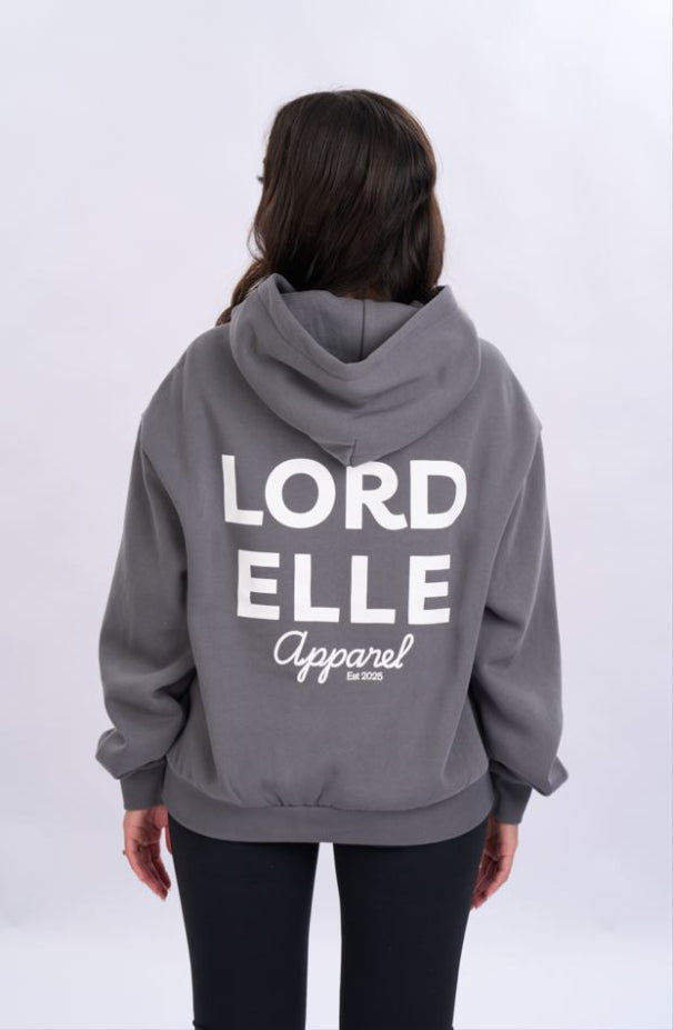 Person wearing a grey hoodie with 'LORD ELLE Apparel' text on the back against a white background