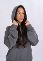 Woman wearing a gray hoodie against a white background