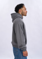 Man wearing a grey hoodie and blue jeans on a white background